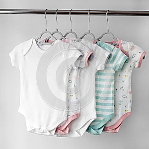 A set of beautiful clothes for a newborn girl on hangers. The concept of clothes, motherhood, fashion and newborn
