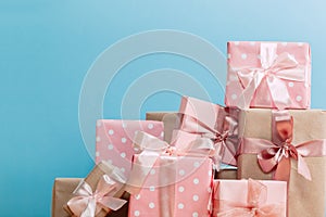 Set of beautiful different gift boxes made by handmade with pink bows on a wooden table with a blue background. flat lay