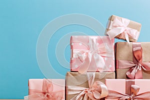 Set of beautiful different gift boxes made by handmade with pink bows on a wooden table with a blue background. flat lay