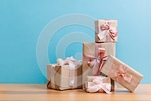 Set of beautiful different gift boxes made by handmade with pink bows on a wooden table with a blue background. flat lay