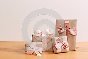 Set of beautiful different gift boxes made by handmade with pink bows on a wooden table with a light background. flat lay
