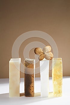 Set of beautiful handmade natural soap with dry leaf on white and brown background.