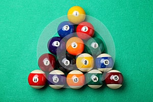 Set of billiard balls on green table, flat lay