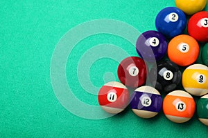 Set of billiard balls on green table, flat lay. Space for text