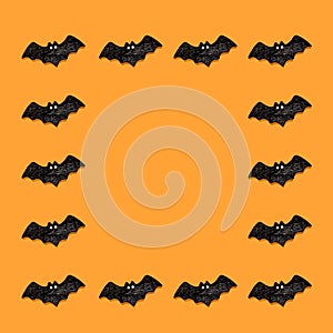 Set of black bats isolated on orange color background. Halloween ornament is colorful Tones