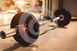 Set of black heavy steel barbells on fitness sport gym floor. Object and exercise concept. Workout training and bodybuilder. Sport