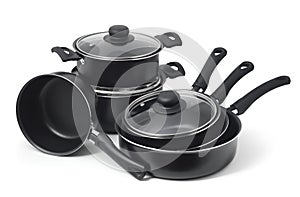 Set of black non-stick kitchen utensils on a white background. Pot, ladle, frying pan  with glass lid