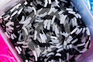 A set of black white striped elastic bands for weaving bracelets for children.