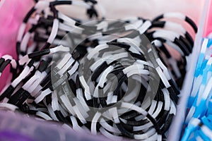 A set of black white striped elastic bands for weaving bracelets for children.