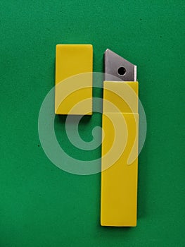 Set of blades for a stationery knife in a yellow plastic box