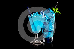 Set of Blue Curacao cocktails garnished with a lime isolated on black background