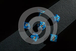 Set of blue role-playing game dice on a black surface