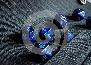 Set of blue role-playing game dice on a pinstripe vest
