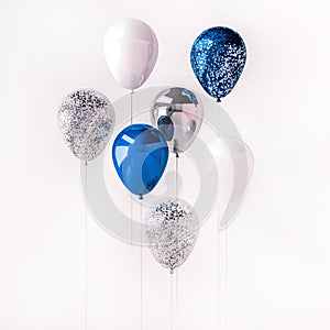 Set of blue and silver glossy balloons on the stick with sparkles on white background. 3D render for birthday, party, wedding or p