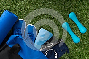 Set of blue things for sports man training lies on green grass background
