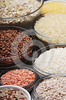 A set of bowls filled with different seeds: buckwheat, rise, corn and oatmeal