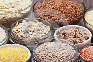 A set of bowls filled with different seeds: buckwheat, rise, corn and oatmeal