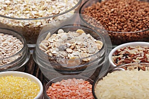 A set of bowls filled with different seeds: buckwheat, rise, corn and oatmeal