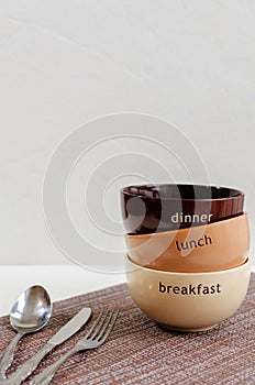 Set of bowls with fork, spoon and knife.