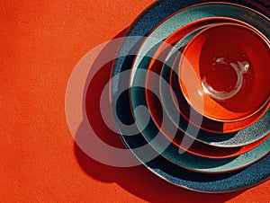 Set of bowls and plates are arranged in a stack on a red background
