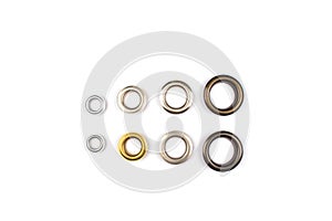 Set of brass multicoloured metal eyelets or rivets - curtains rings for fastening fabric to the cornice, isolated on