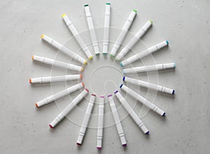 A set of bright multi-colored felt-tip pens or markers lie in a circle, rays, creating a round frame in the center. Creativity,