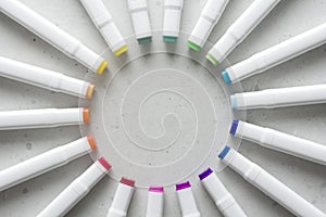 A set of bright multi-colored felt-tip pens or markers lie in a circle, rays, creating a round frame in the center. Creativity,