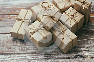 Set of brown gift boxes on wooden background. Wrapped in craft paper and tied by hemp cord. A lot of parcels.