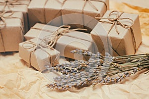 Set of brown gift boxes. Wrapped in craft paper and tied by hemp cord. Old paper background. Small lavender bouquet.