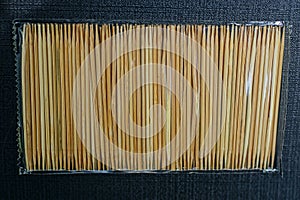 Set of brown wooden toothpicks in transparent plastic cellophane packaging