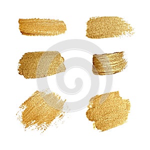 Set of brush strokes of gold paint. Abstract gold glittering textured art illustration.