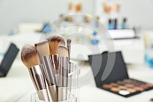 Set of brushes and other makeup products on dressing table