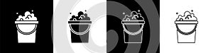 Set Bucket with soap suds icon isolated on black and white background. Bowl with water. Washing clothes, cleaning