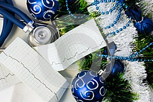 Set of cardiac diagnostic instruments with Christmas or New Year decorations. Stethoscope and pulse trace ECG tape lying near art