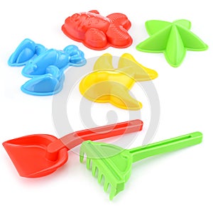 A set of children's toys for playing in the sandbox. Colored rake and shovel made of plastic, isolated on a