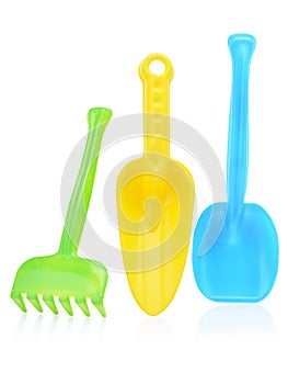 A set of children's toys for playing in the sandbox. Colored rake and shovel made of plastic, isolated on a