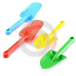 A set of children's toys for playing in the sandbox. A lot of colorful plastic shovels, isolated on a white