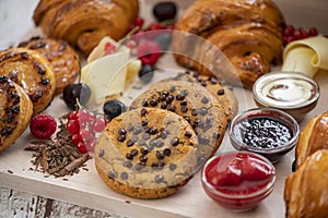 Set of chocolate croissants and cookies with syrups  decorated with berries