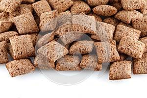 Set of chocolate pillows for breakfast isolated on white background. Brown choco cereal pads with vanilla, crispy flakes, healthy