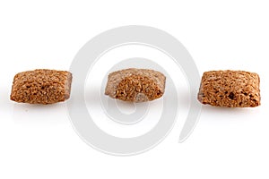 Set of chocolate pillows for breakfast isolated on white background. Brown choco cereal pads with vanilla, crispy flakes, healthy