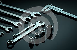 Set of chrome wrenches or spanners, hexagon socket, and vernier caliper on dark table in workshop. Chrome vanadium spanner wrench