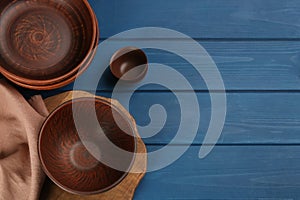 Set of clay utensils on blue wooden table  flat lay. Space for text