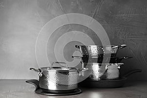 Set of clean cookware on table against grey background.