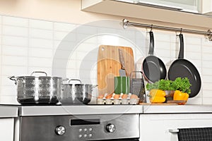 Set of clean cookware, utensils and products on table