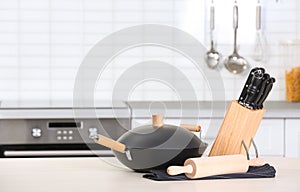 Set of clean cookware and utensils on table in kitchen
