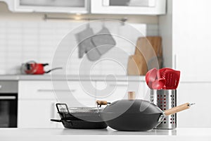 Set of clean cookware and utensils on table in kitchen