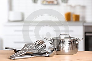 Set of clean cookware and utensils on table in kitchen