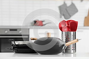 Set of clean cookware and utensils on table in kitchen