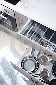 Set of clean kitchenware and utensils in open drawers