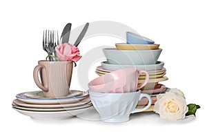 Set of clean tableware with flowers on white background